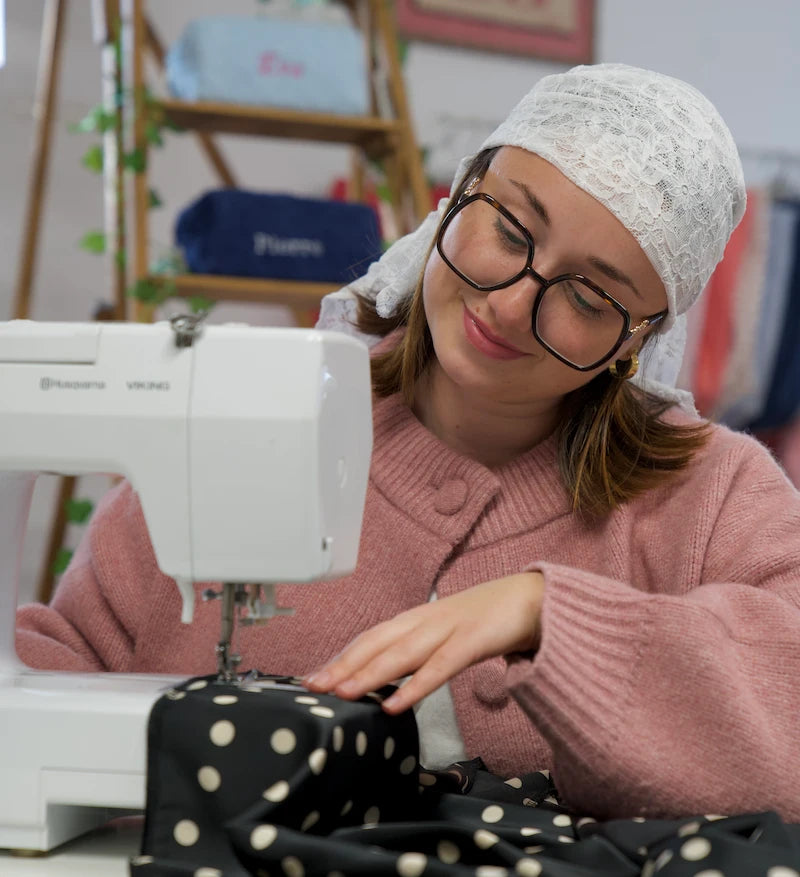 Créatrice cousant dans son atelier de broderie personnalisée à Montbrison